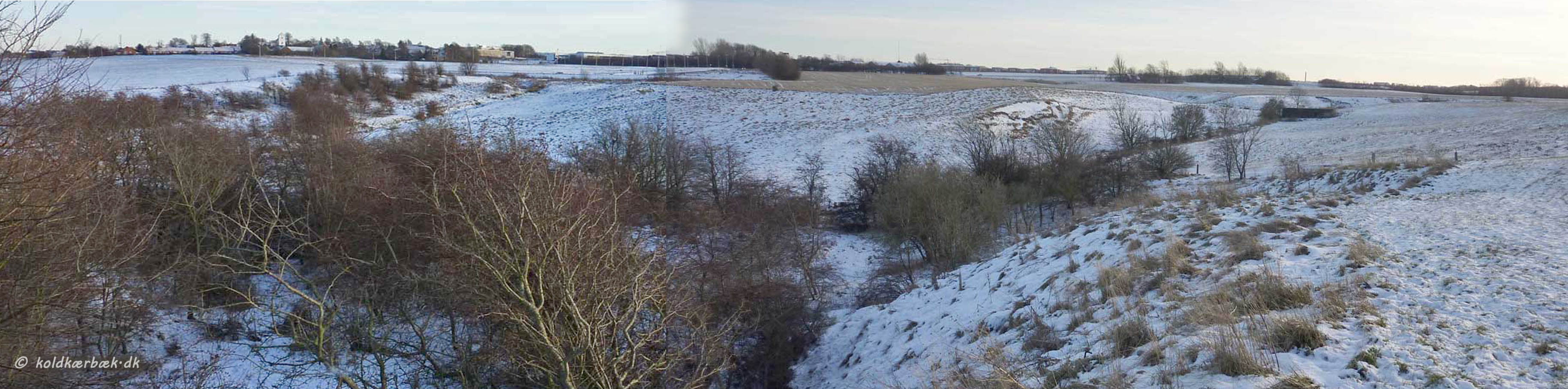 Koldkær Bæk 4-1-2010. Vinterlandskab fra før anlæggelsen af hovedforløbet af Palludan Müllersvej og Letbanen. Ligeleses er byggeriet af Det Ny Universitetshospital ikke gået igang. Endelig sees den begyndende tilgroning af overdrevet langs Koldkær Bæk